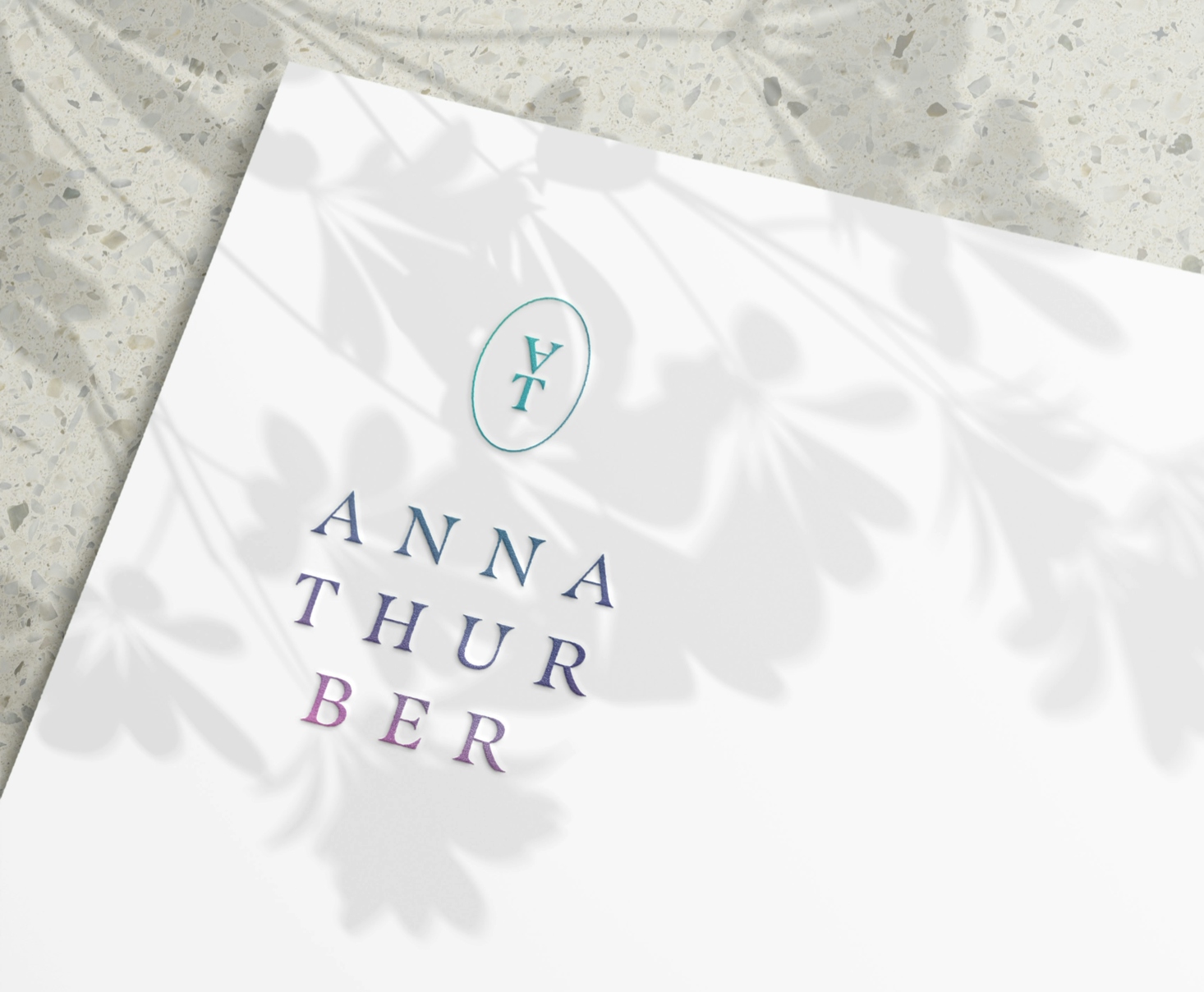 A logo for “Anna Thurber” on a page with shadows of leaves