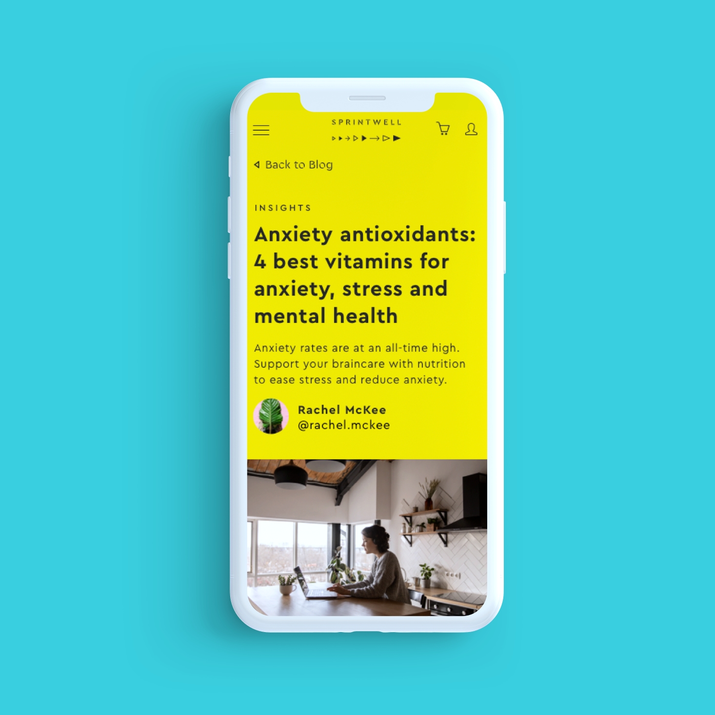 A white mobile phone sits on a teal background and shows a yellow webpage about “Anxiety antioxidants: 4 best vitamins for anxiety, stress and mental health”. There is illustrative text and a picture of a woman on a laptop sitting in a kitchen is at the bottom of the page.