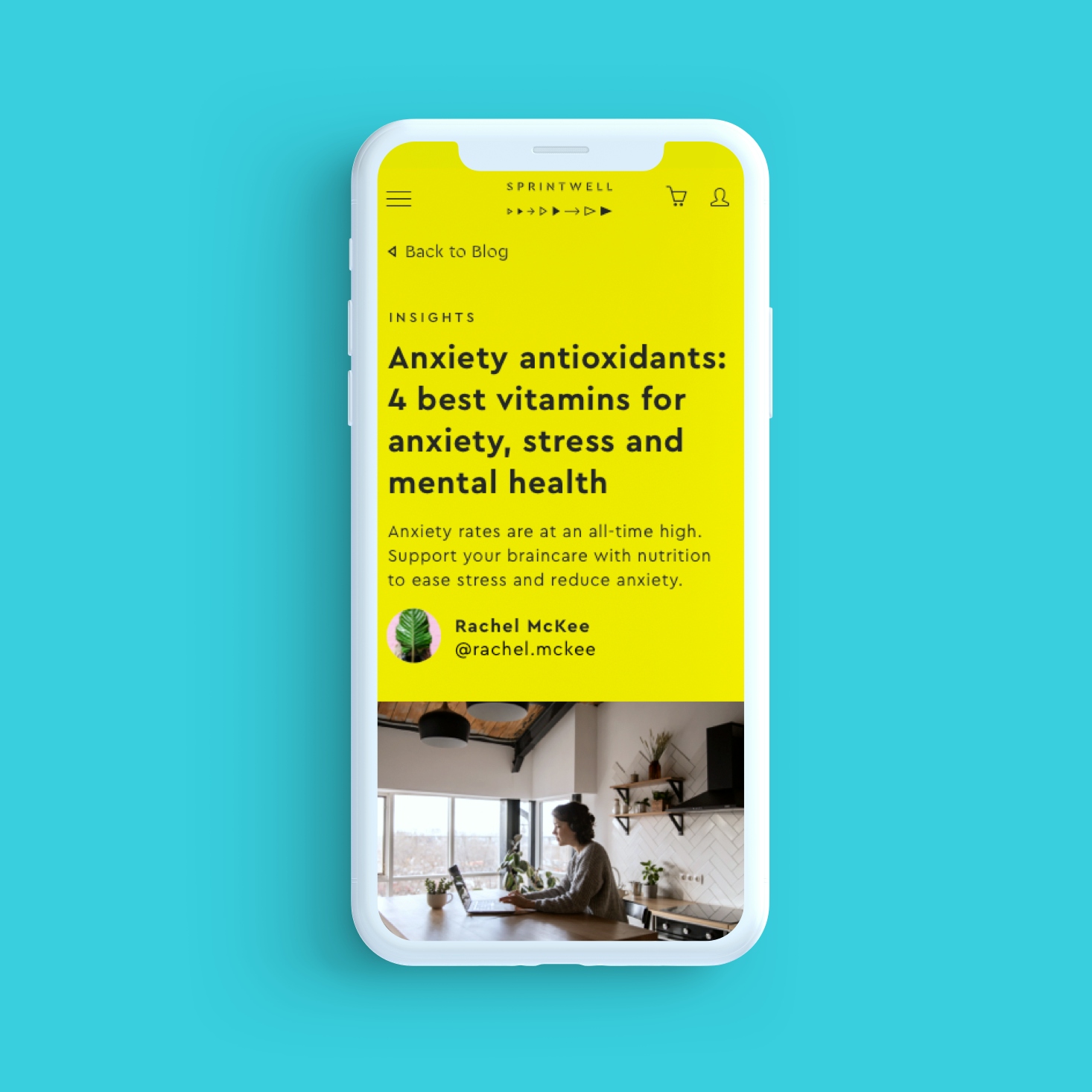 A white mobile phone sits on a teal background and shows a yellow webpage about “Anxiety antioxidants: 4 best vitamins for anxiety, stress and mental health”. There is illustrative text and a picture of a woman on a laptop sitting in a kitchen is at the bottom of the page.
