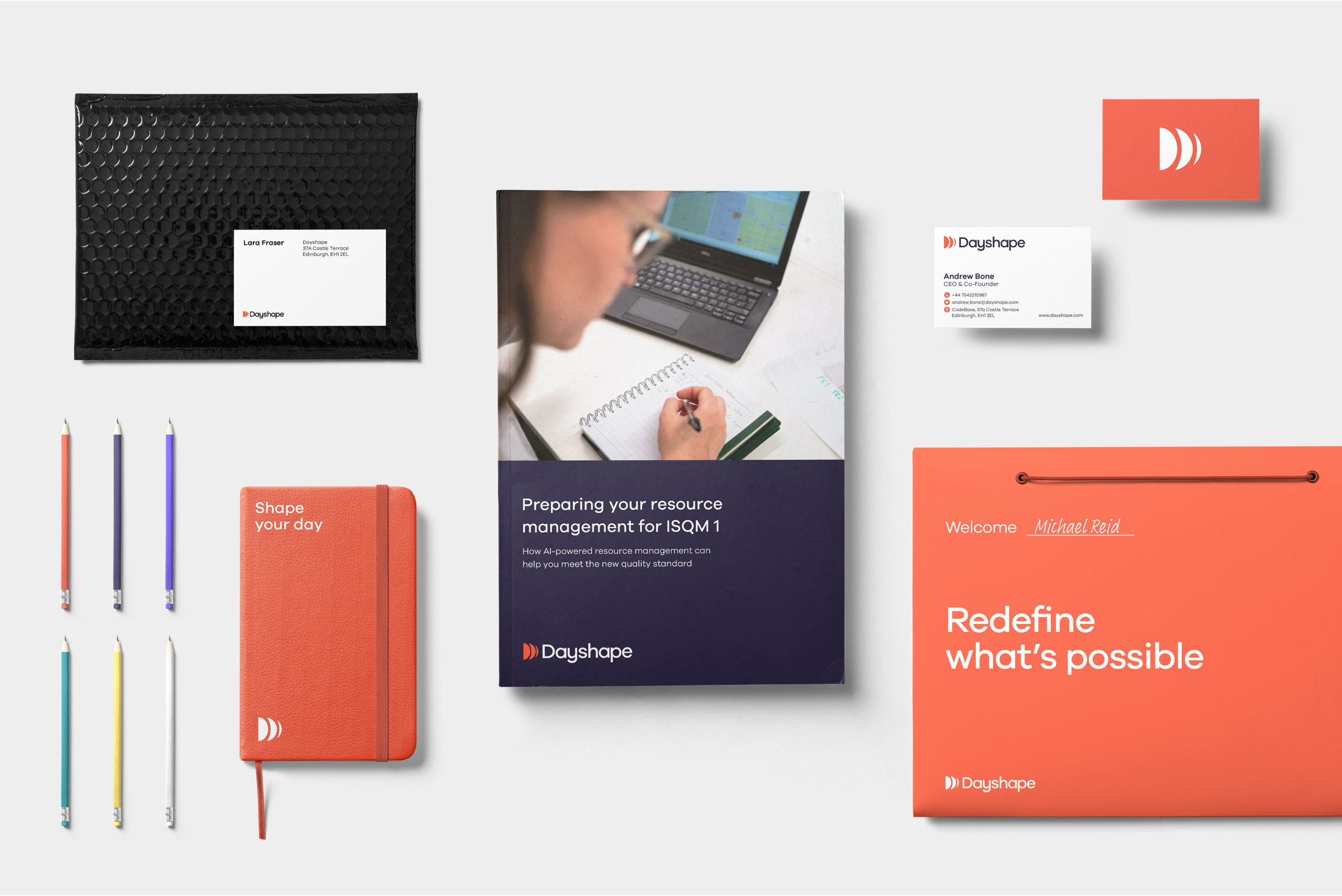 A montage of business cards, promotional items and company onboarding materials with Dayshape identity branding. An orange folder states “”Redefine what’s possible and a pad state “Shape your day”